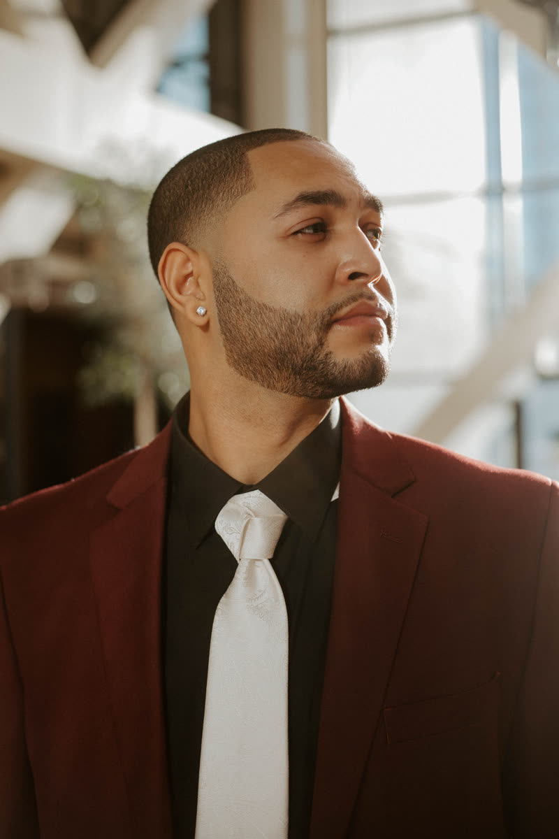 Portrait of Christian King Atlas in a maroon blazer and white tie